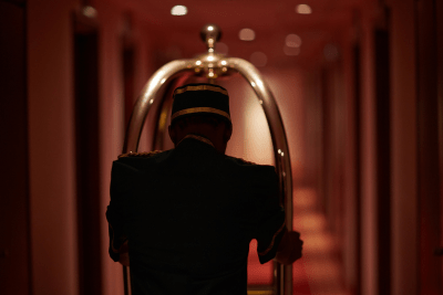 bellhop with luggage cart in hallway