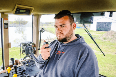 man uses GMRS two-way radio in tractor cab