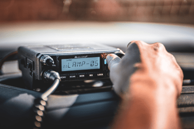 man turns knob of Midland MXT500 MicroMobile GMRS Two-Way Radio