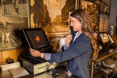woman uses business radio headset at POS station of a restaurant