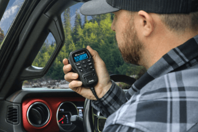 man holds Fully-Integrated microphone in Jeep
