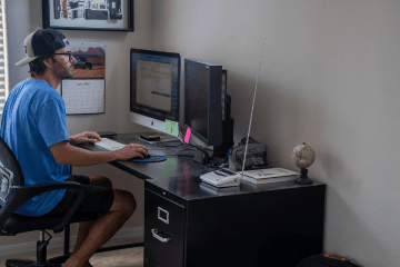 man sits at desk with weather radio