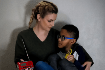 woman and child hold emergency radio