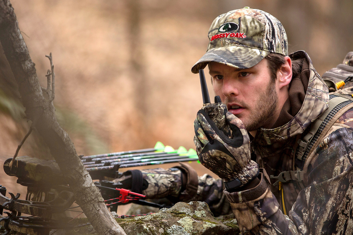 man holds camo walkie talkie