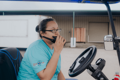 woman in golf cart using walkie talkie