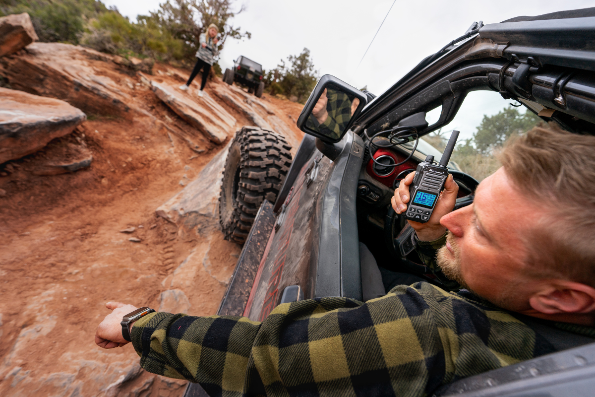 man uses walkie talkie out of side by side