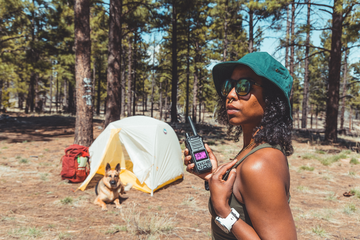 woman holds walkie talkie at campsite