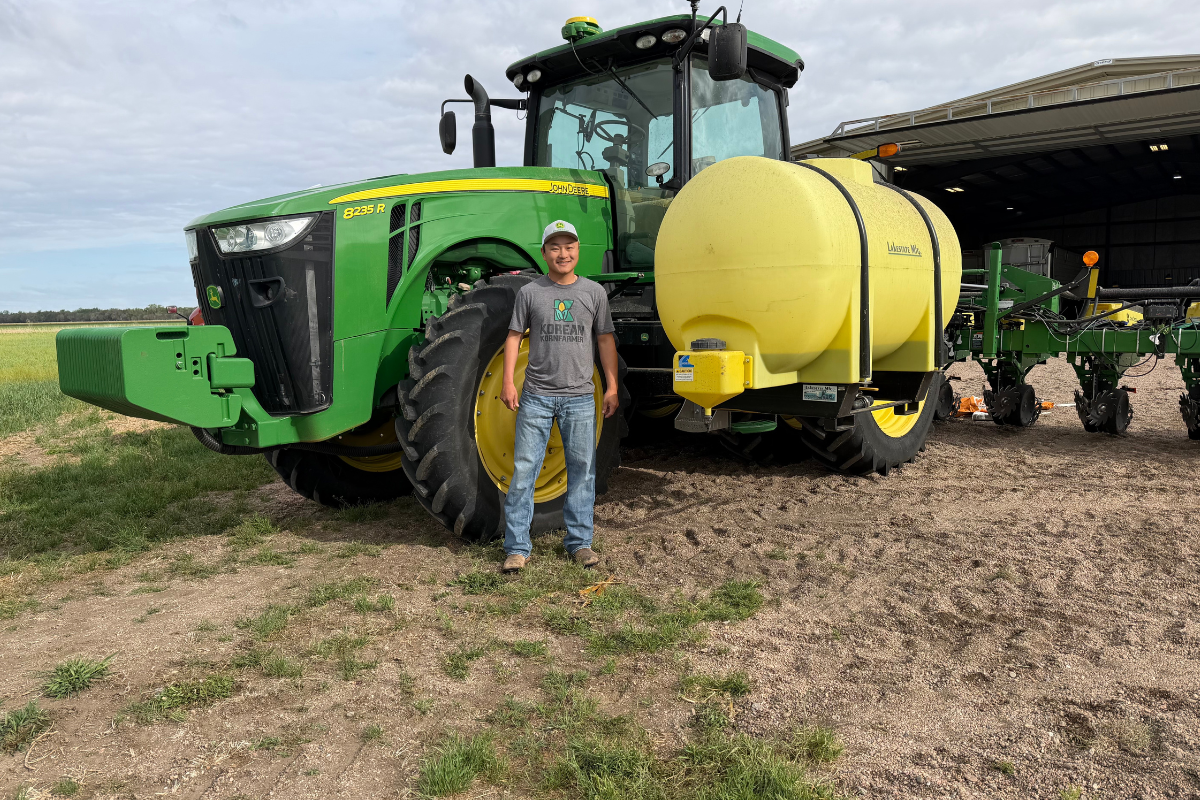 man standing in front of tractor on farm