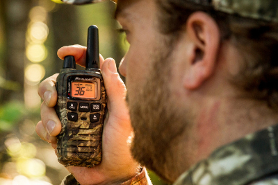 man holds camo walkie talkie