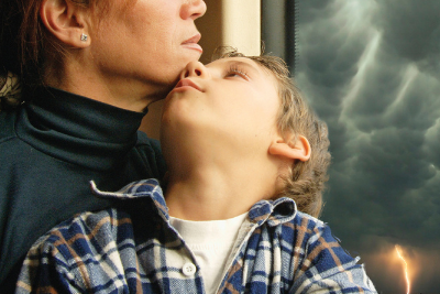 mom and son look out stormy window