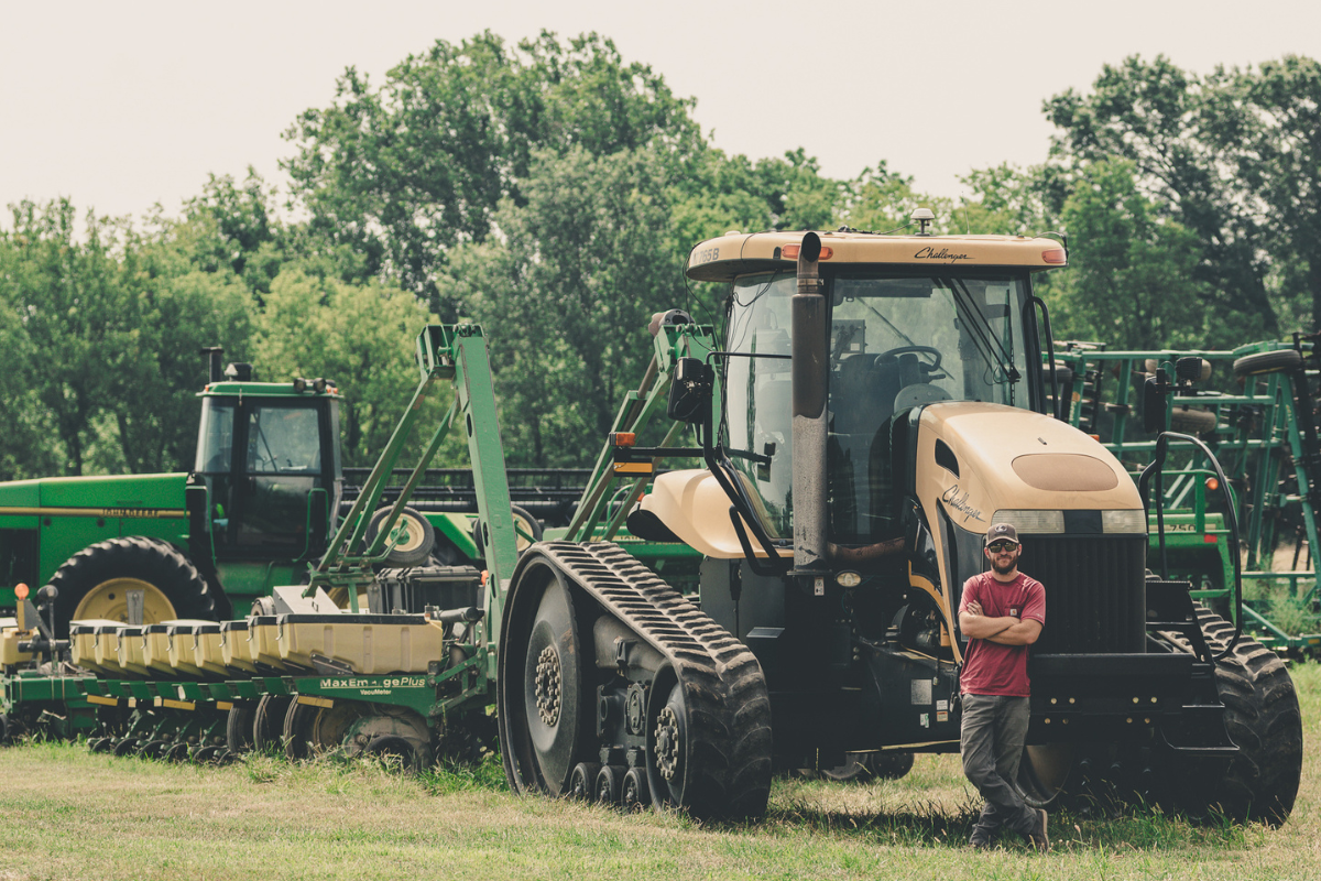 man stands by tractor on farm