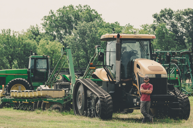 man stands by tractor on farm