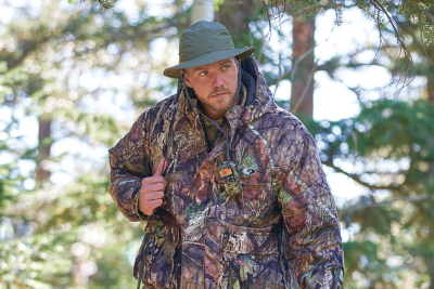 hunter walks in woods in camo