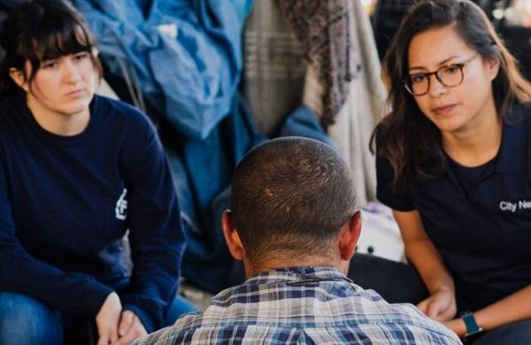 group of three people talk in circle