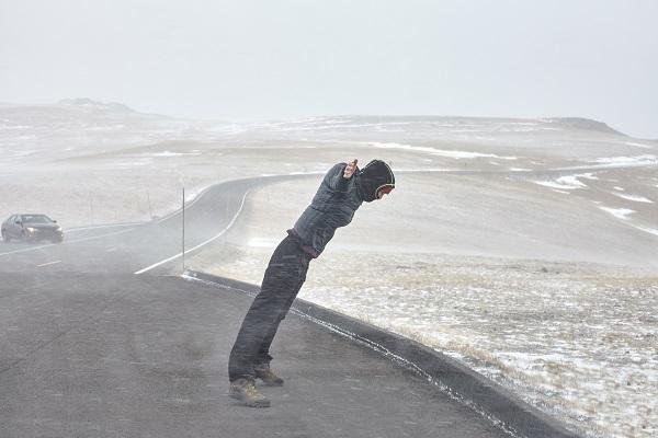 man stands in snowy wind storm