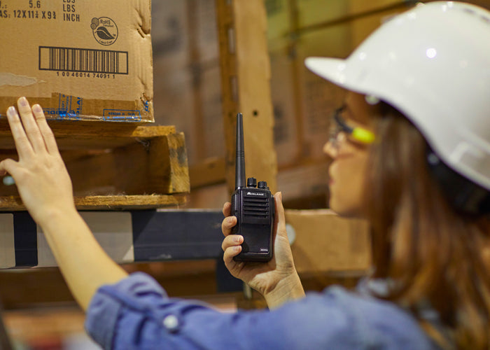woman uses business radio in warehouse