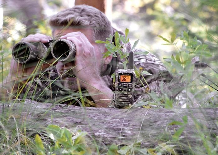man uses binoculars in woods