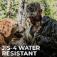 Man in camouflage gear with a dog, holding a JIS-4 water-resistant device in a forest setting.