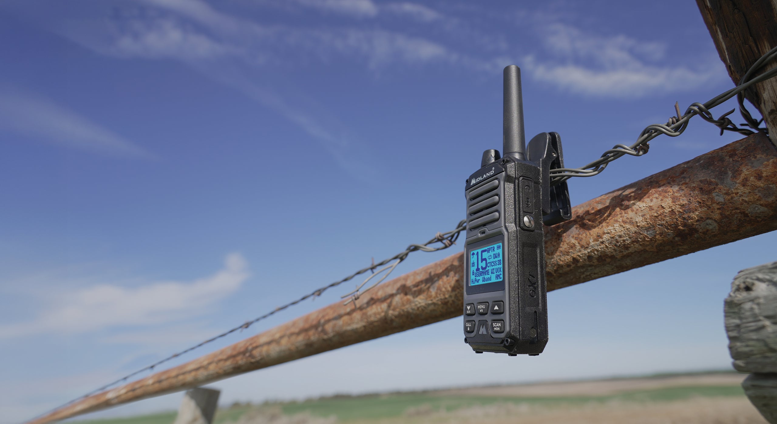 Black walkie-talkie on a wooden fence with a blue sky background