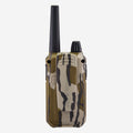 A walkie-talkie with a camouflage pattern in olive green, tan, and black, featuring a tall black antenna and a black top knob, shown against a plain light gray background.