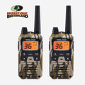 Two Midland walkie-talkies with a tan and green camouflage pattern, shown side by side on a light gray background with the Mossy Oak Bottomland logo in the top left corner.